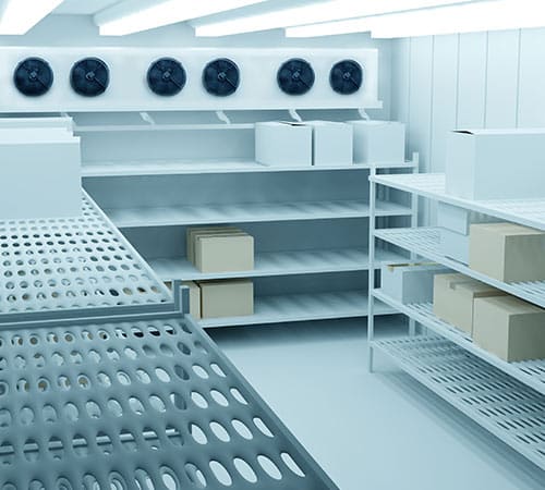 Intérieur d'une chambre froide moderne avec des étagères remplies de cartons et cinq grandes unités de ventilation murales.